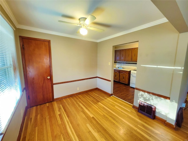 spare room featuring crown molding, sink, ceiling fan, and light hardwood / wood-style floors