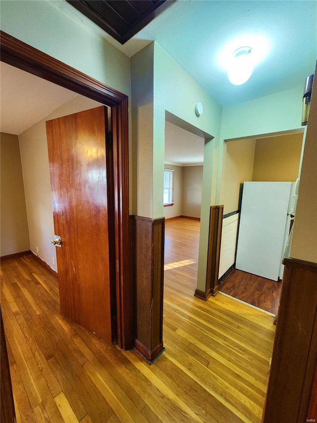 corridor with light hardwood / wood-style floors