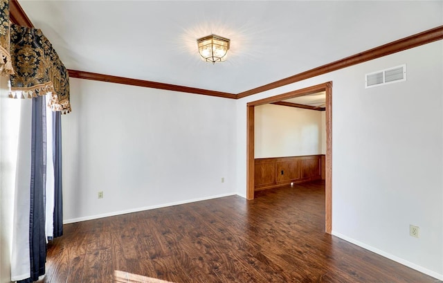 empty room featuring crown molding and dark wood-type flooring