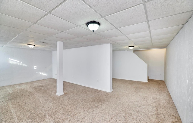 basement featuring a drop ceiling and carpet floors