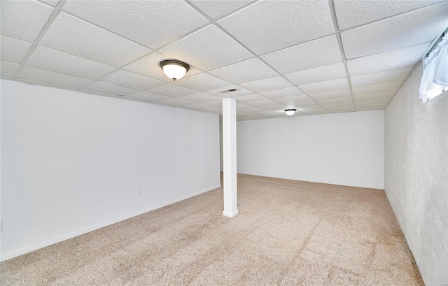 basement featuring carpet flooring and a paneled ceiling