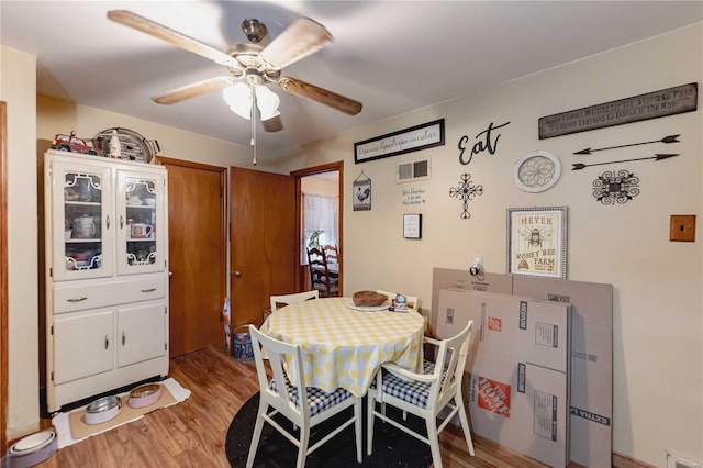 dining space with light wood-type flooring and ceiling fan