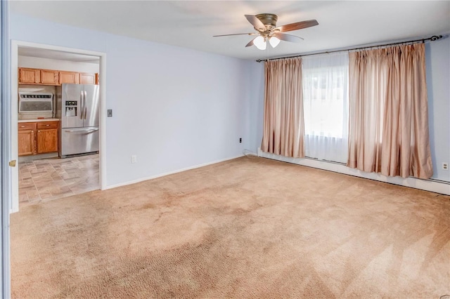 spare room featuring light carpet, a baseboard radiator, and ceiling fan