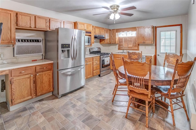 kitchen featuring a wall mounted air conditioner, backsplash, sink, ceiling fan, and stainless steel appliances