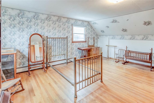 bonus room with hardwood / wood-style floors, lofted ceiling, and a baseboard heating unit