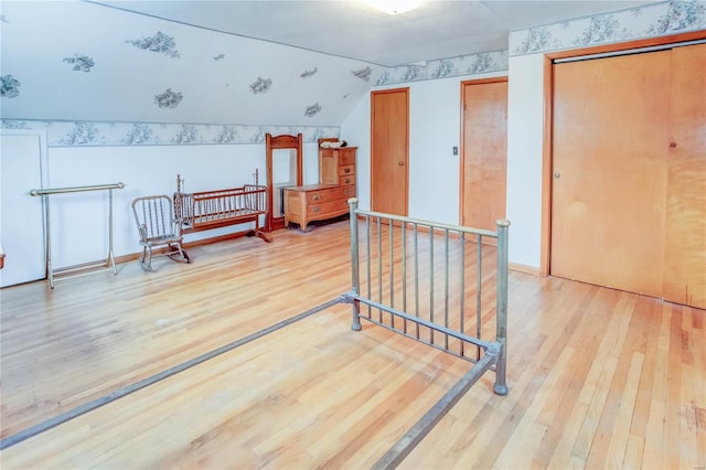 additional living space featuring light hardwood / wood-style floors and vaulted ceiling