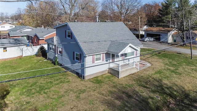 rear view of property featuring a porch and a yard