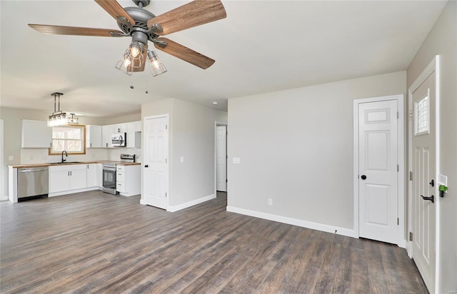 unfurnished living room with a wealth of natural light, dark wood-type flooring, and sink