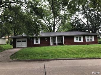 ranch-style house with a garage and a front lawn