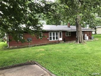 rear view of property with a lawn