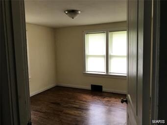 empty room featuring dark hardwood / wood-style flooring