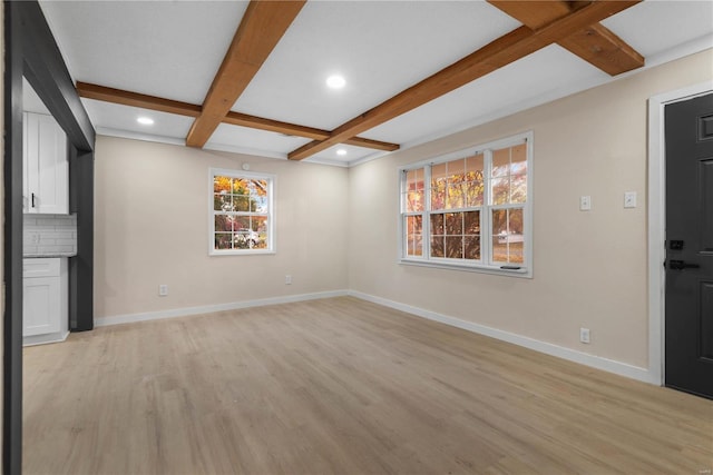 unfurnished living room with beamed ceiling and light wood-type flooring