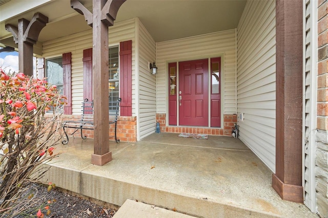 view of exterior entry featuring covered porch