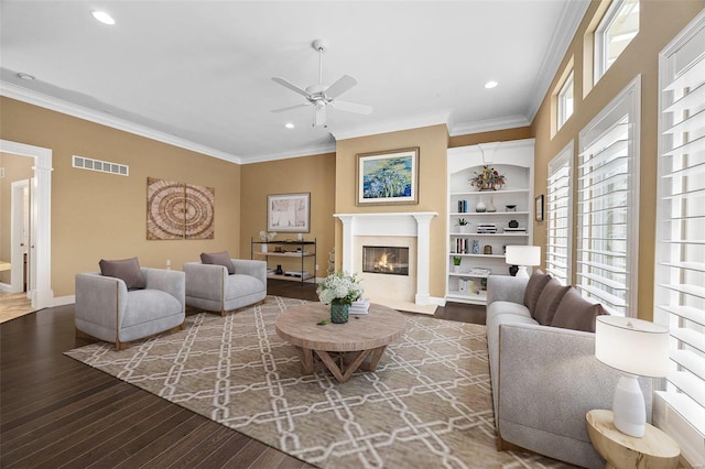 living room with hardwood / wood-style floors, ceiling fan, and crown molding