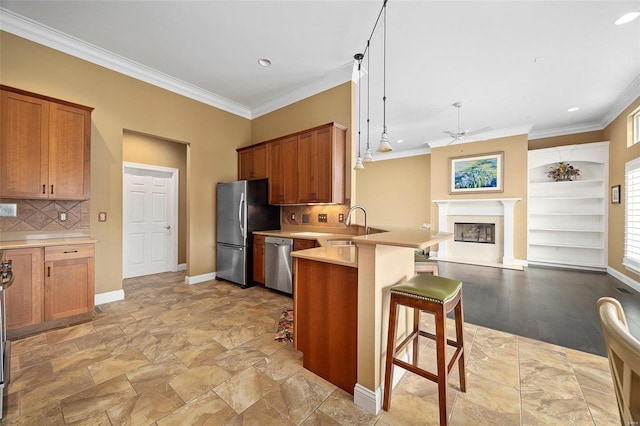 kitchen featuring kitchen peninsula, a kitchen bar, stainless steel appliances, and ornamental molding