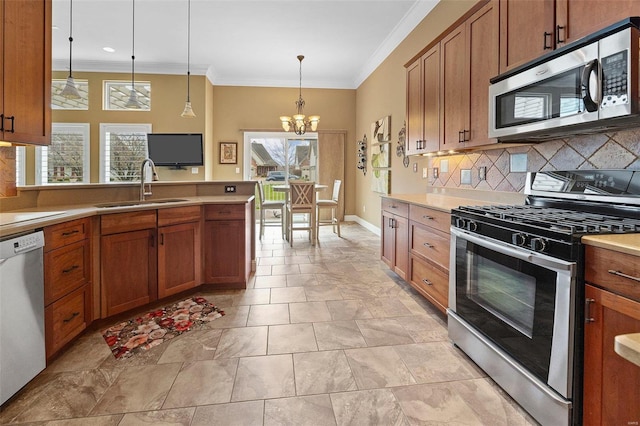 kitchen with appliances with stainless steel finishes, a healthy amount of sunlight, pendant lighting, and sink