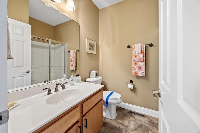 bathroom featuring vanity, toilet, and walk in shower