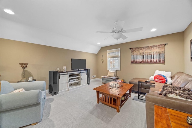 carpeted living room with ceiling fan and vaulted ceiling