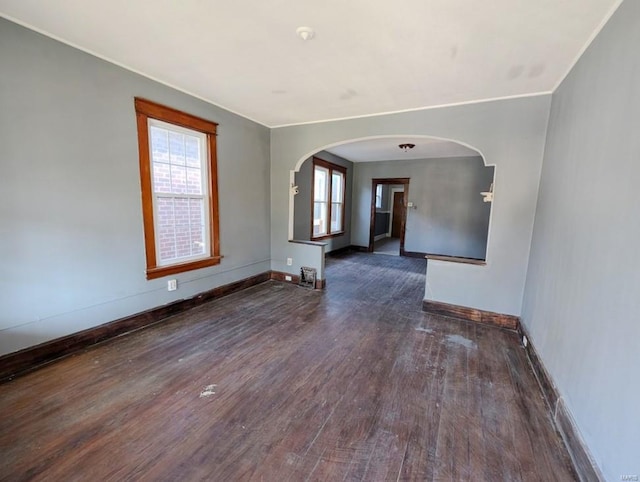 spare room featuring plenty of natural light and dark wood-type flooring