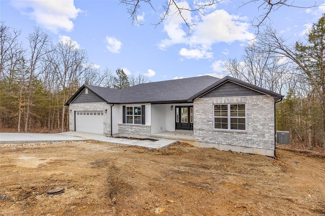 view of front of property with an attached garage, a shingled roof, and concrete driveway