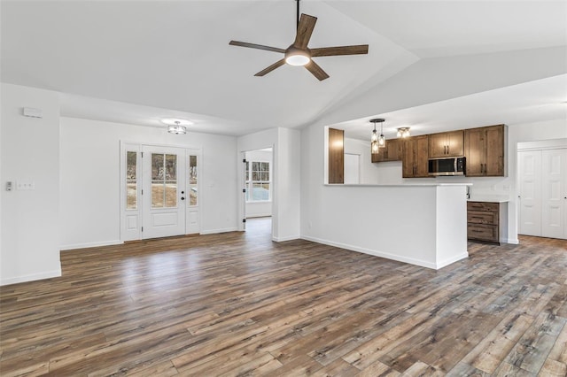 unfurnished living room with vaulted ceiling, dark wood-style flooring, ceiling fan, and baseboards