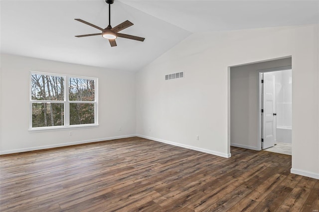 spare room featuring dark wood finished floors, lofted ceiling, visible vents, a ceiling fan, and baseboards