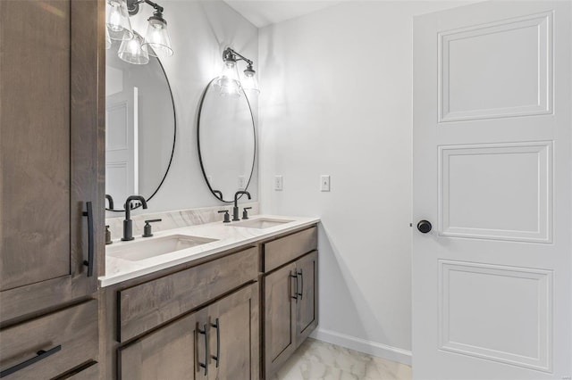 full bathroom featuring marble finish floor, double vanity, a sink, and baseboards