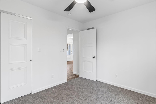 unfurnished bedroom with carpet flooring, ceiling fan, visible vents, and baseboards