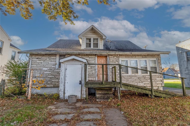 view of front of house with stone siding and a shingled roof