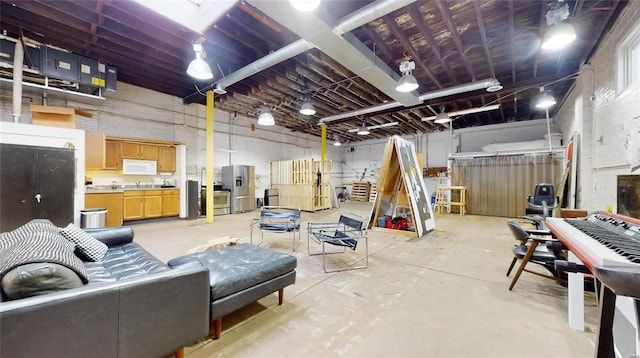 basement featuring sink and stainless steel refrigerator with ice dispenser