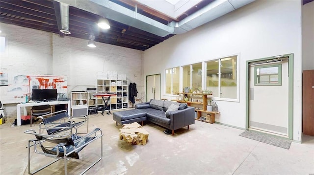 living room featuring concrete flooring and a high ceiling