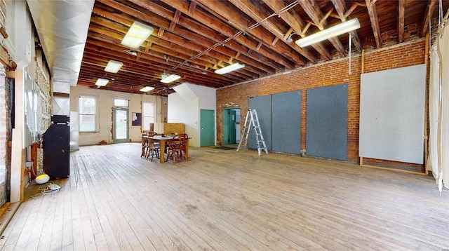 basement with hardwood / wood-style flooring and brick wall