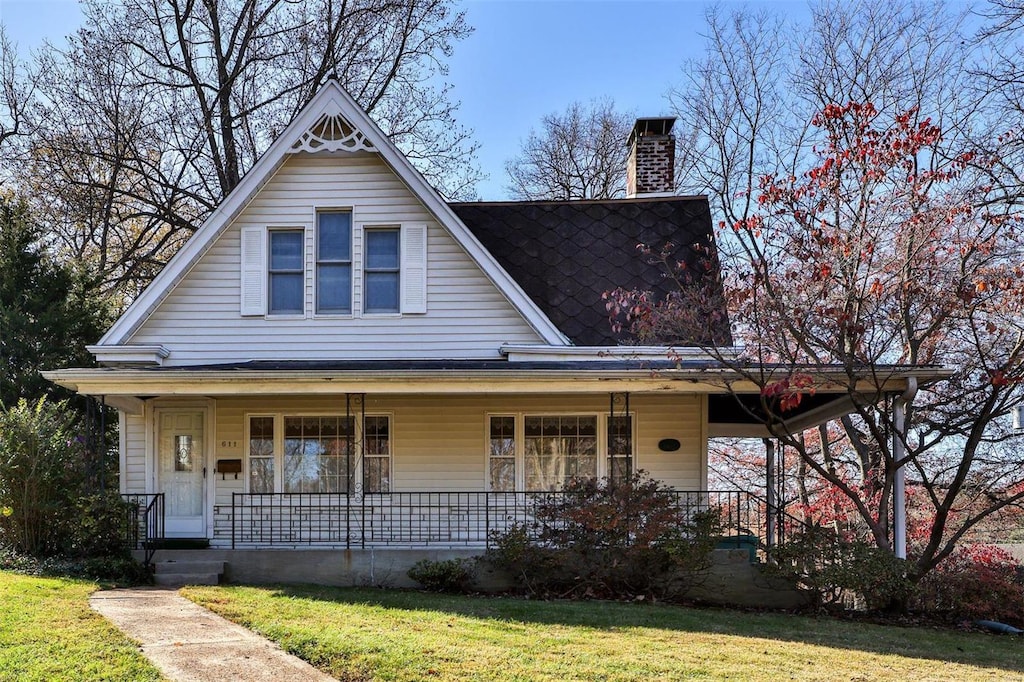 view of front of house with covered porch and a front lawn