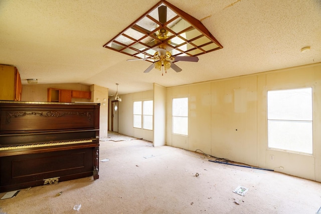 interior space featuring ceiling fan, light colored carpet, a textured ceiling, and vaulted ceiling