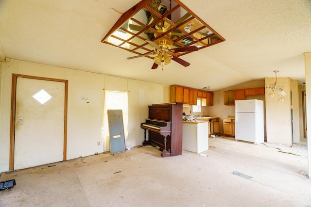 kitchen with pendant lighting, white fridge, vaulted ceiling, and a wealth of natural light