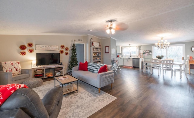 living room with dark hardwood / wood-style floors, a textured ceiling, lofted ceiling, ceiling fan with notable chandelier, and ornamental molding