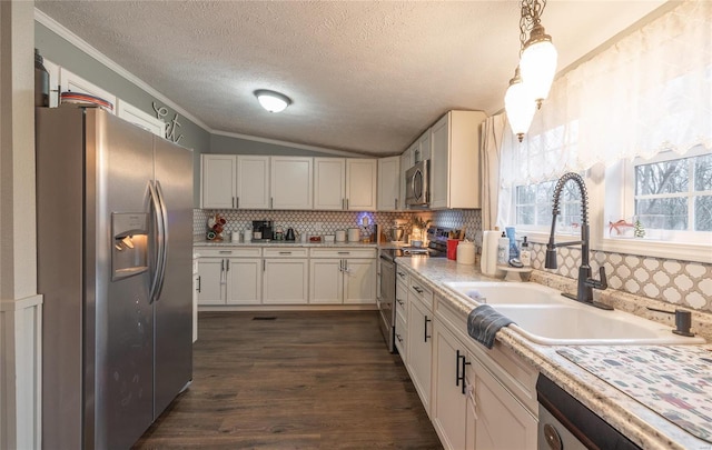 kitchen with white cabinetry, sink, decorative light fixtures, and appliances with stainless steel finishes