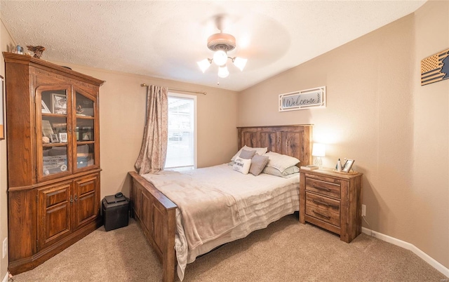 carpeted bedroom with a textured ceiling, vaulted ceiling, and ceiling fan