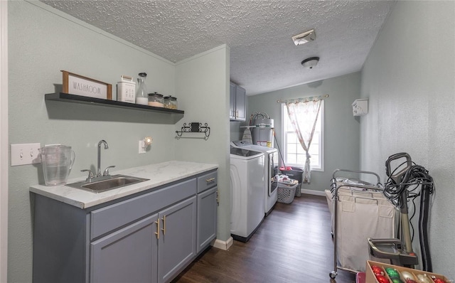 washroom with sink, cabinets, dark wood-type flooring, a textured ceiling, and washer and clothes dryer