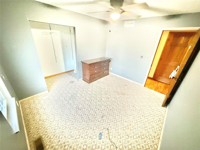 unfurnished bedroom featuring light colored carpet, a closet, and ceiling fan