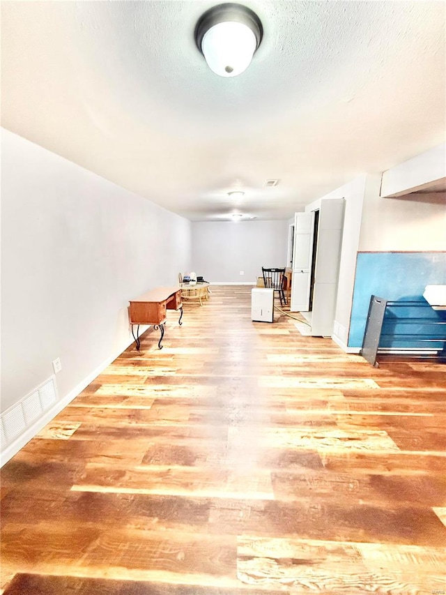 interior space featuring a textured ceiling and light wood-type flooring