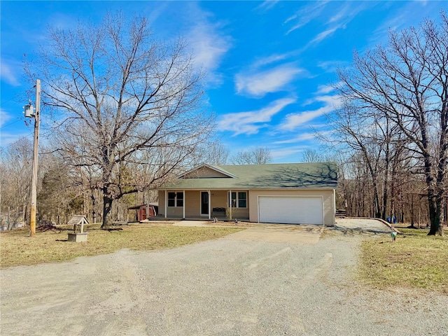 single story home with a porch, driveway, and a garage