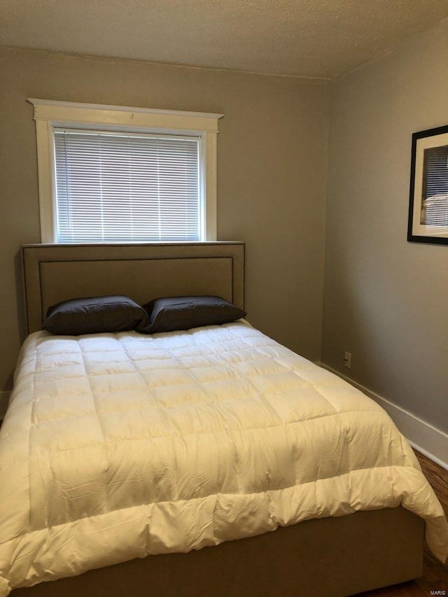 bedroom with hardwood / wood-style flooring and a textured ceiling