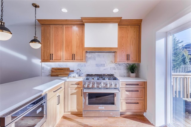 kitchen with high end stainless steel range oven, premium range hood, pendant lighting, light hardwood / wood-style floors, and decorative backsplash