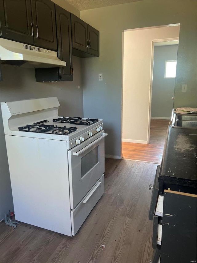 kitchen with dark hardwood / wood-style flooring, dark brown cabinetry, and white range with gas stovetop