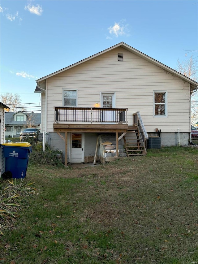 rear view of property with a deck and a yard