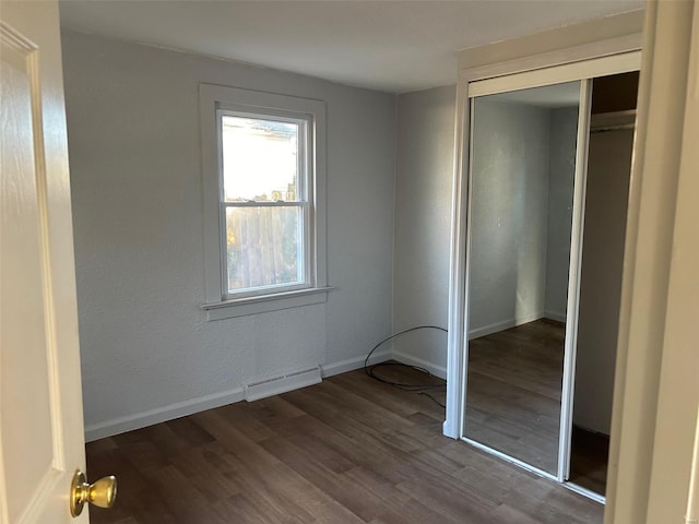 unfurnished bedroom featuring dark hardwood / wood-style floors and a closet