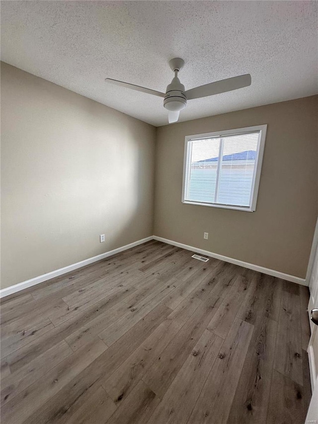 spare room featuring a textured ceiling, light hardwood / wood-style floors, and ceiling fan