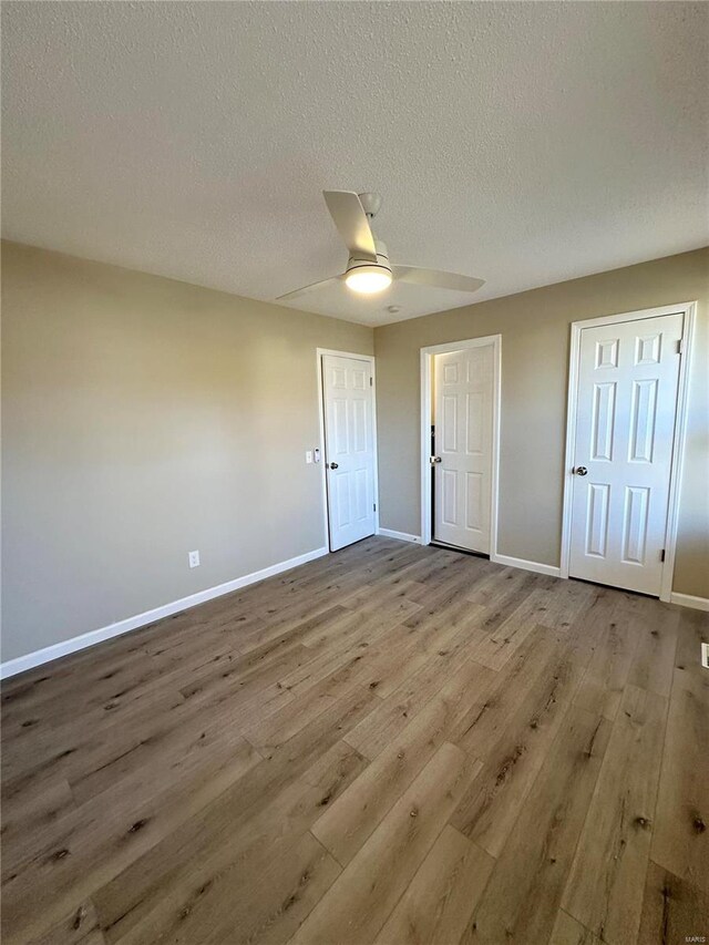 unfurnished bedroom featuring ceiling fan, a textured ceiling, and light hardwood / wood-style flooring