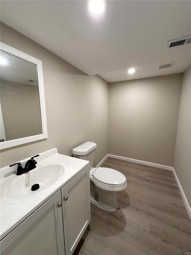 bathroom featuring toilet, vanity, and hardwood / wood-style flooring